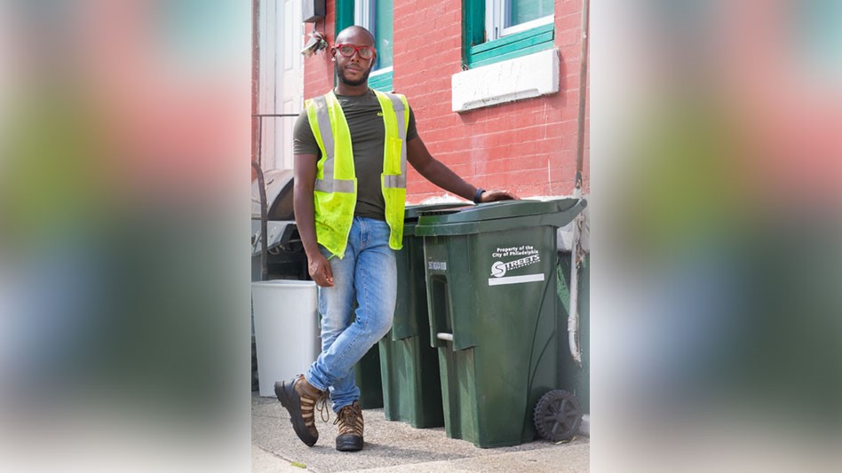 Man standing next to waste container