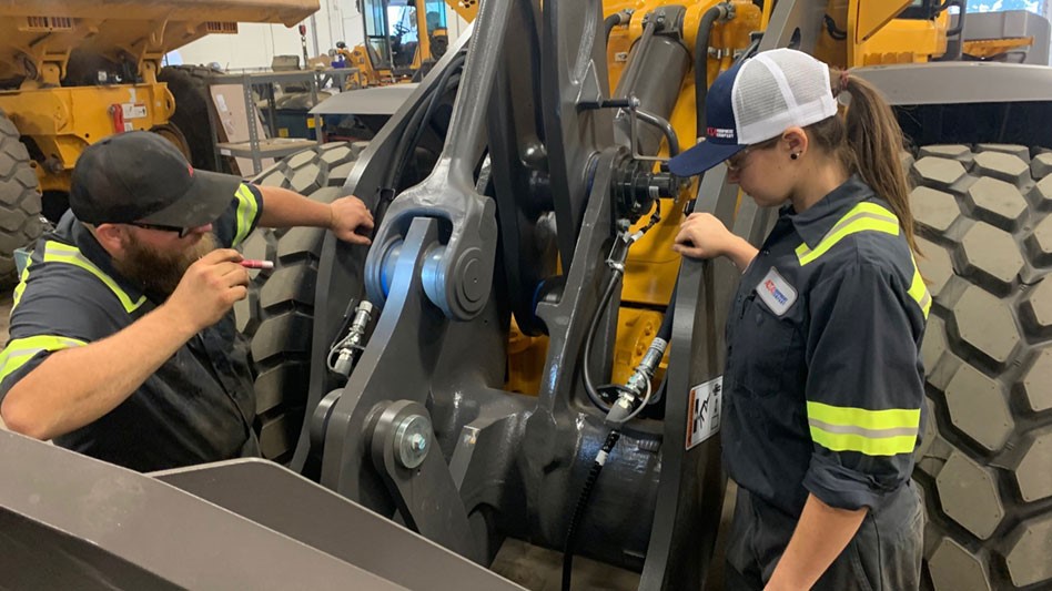 Two Alta Equipment technicians examine a wheel loader.