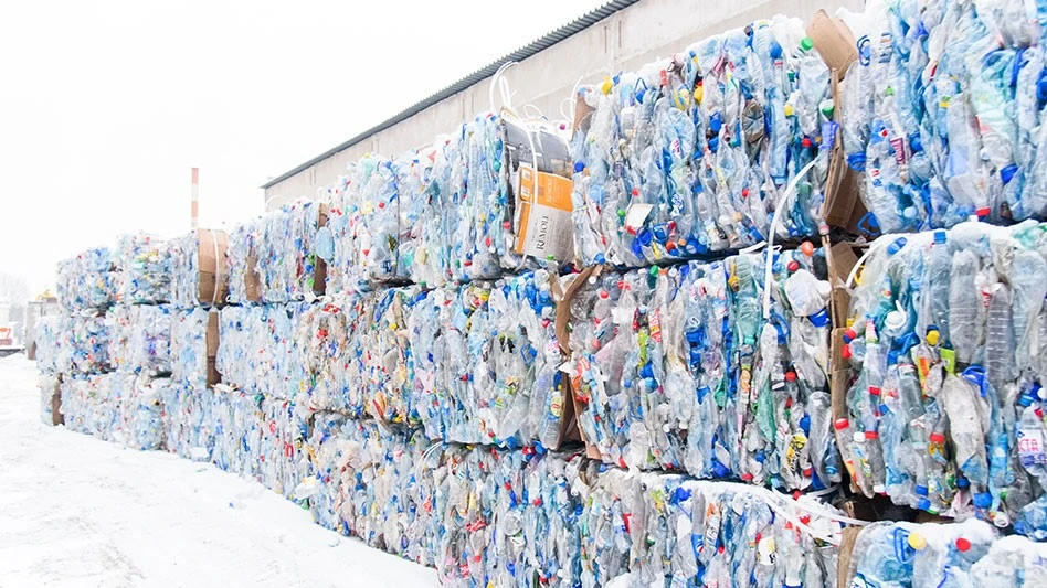 bales of pet bottles stacked outside a building