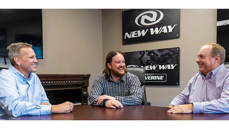 three men sit around a table with new way signs in the background
