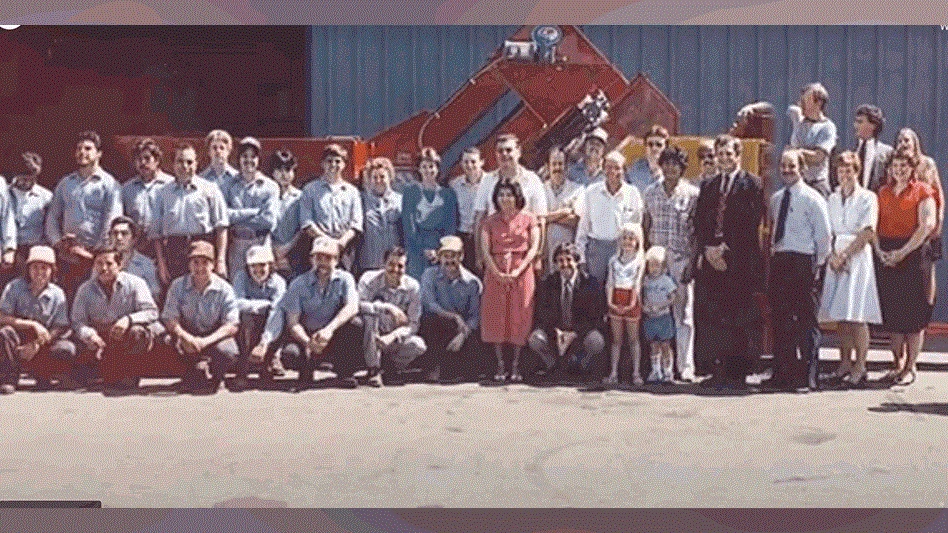  a group of people pose before a piece of recycling equipment