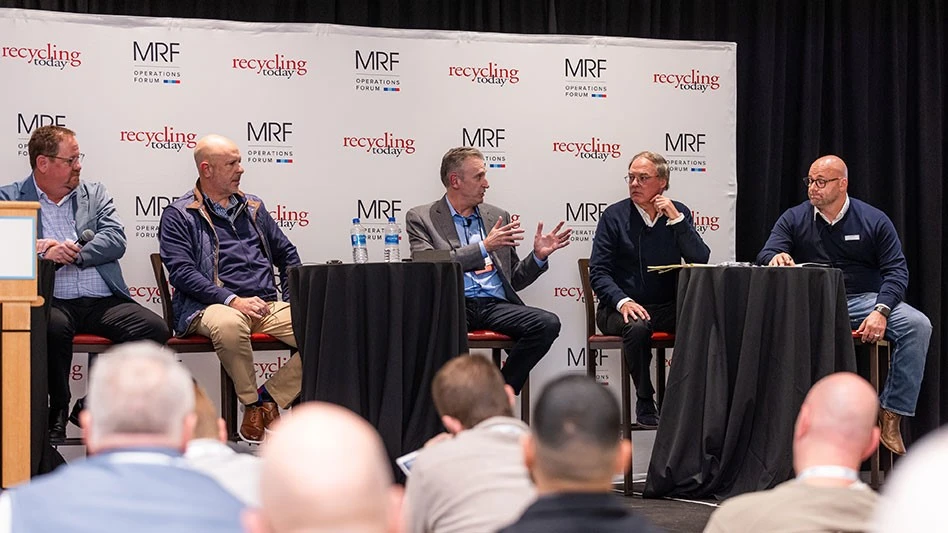 Five men on a stage having a discussion