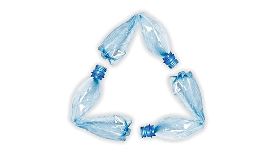 crushed blue plastic bottles in the form of the recycling symbol