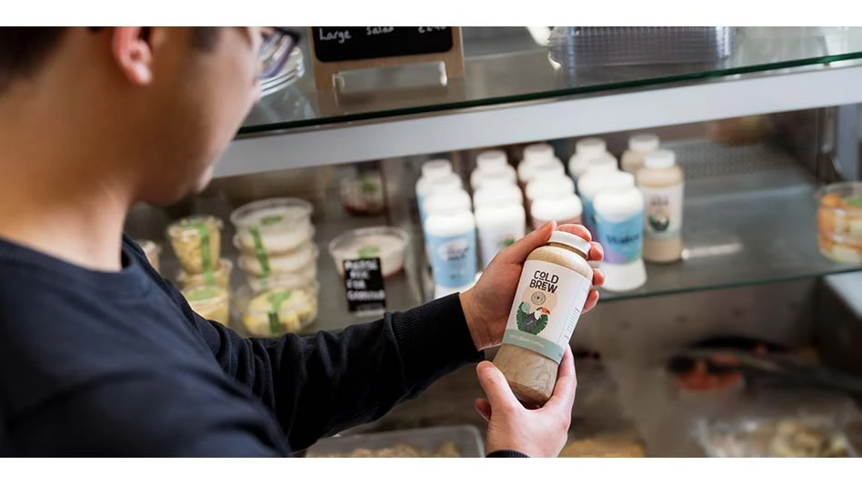 Man holding a dry molded fiber bottle