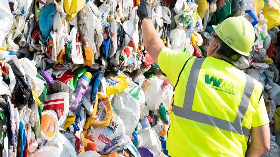 WM worker and bales of recycling