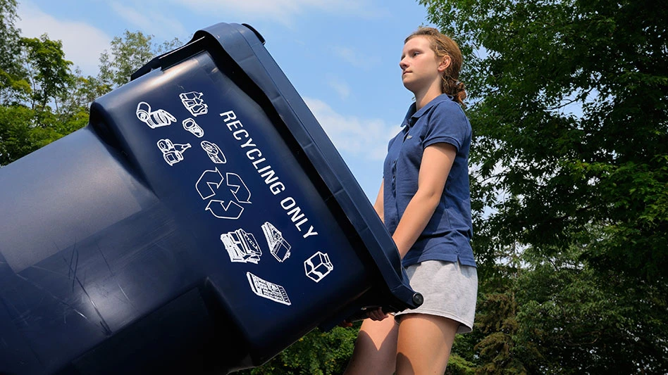 redheaded girl wheeling recycling cart
