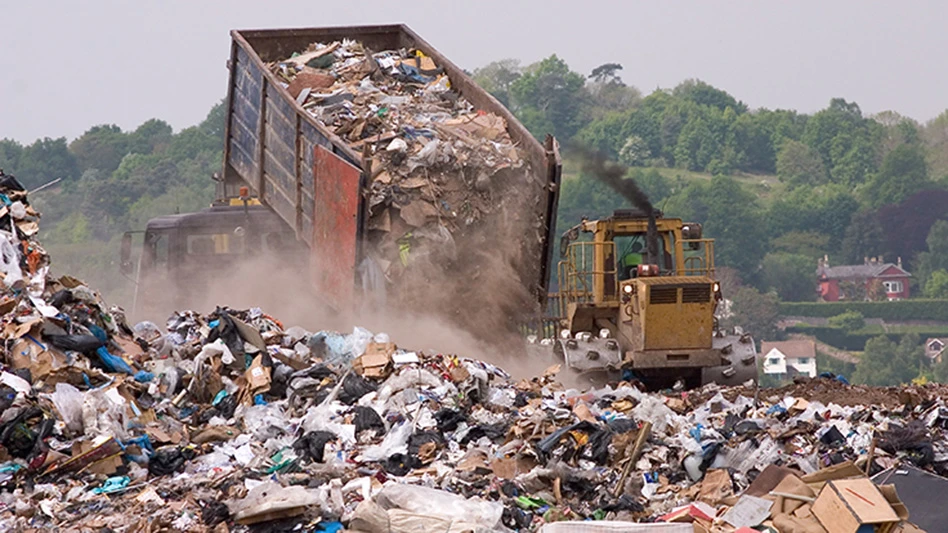 refuse truck tips load at landfill