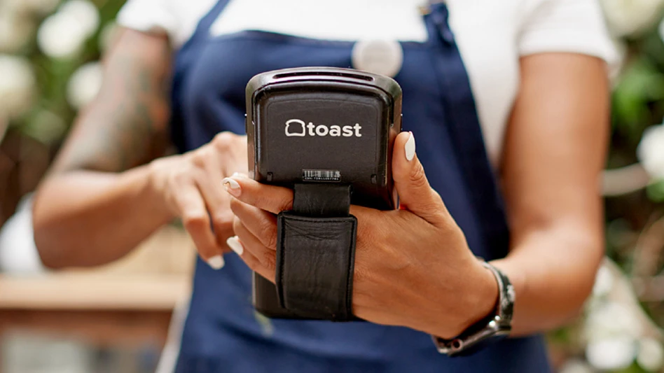 person in apron holding Toast device