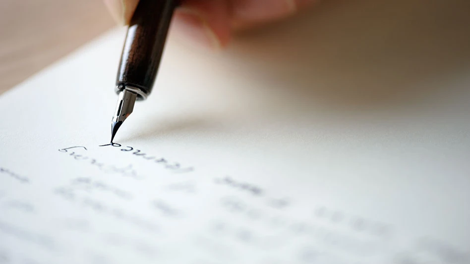 an ink pen writing on a piece of white paper