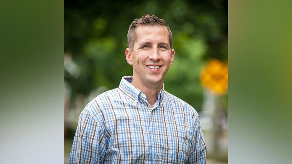 a smiling man in a plaid shirt