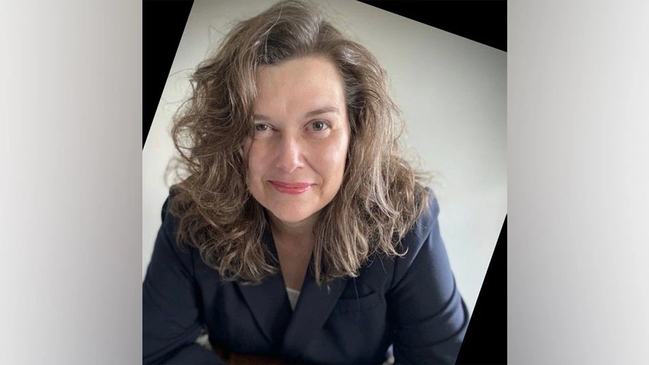 white woman with wavy brown hair smiles for headshot