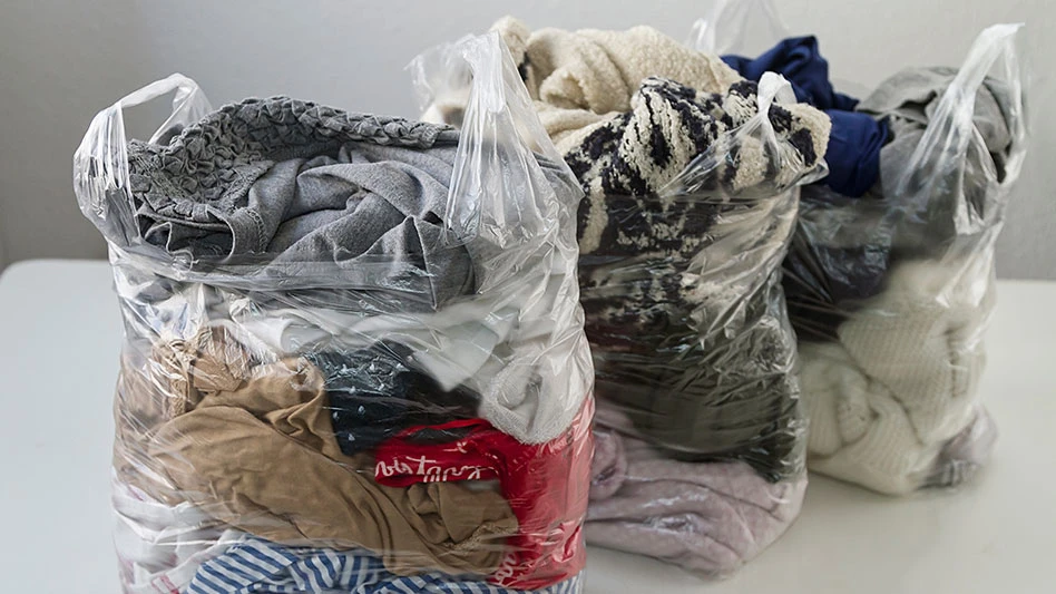 clear plastic shopping bags of clothes for donating