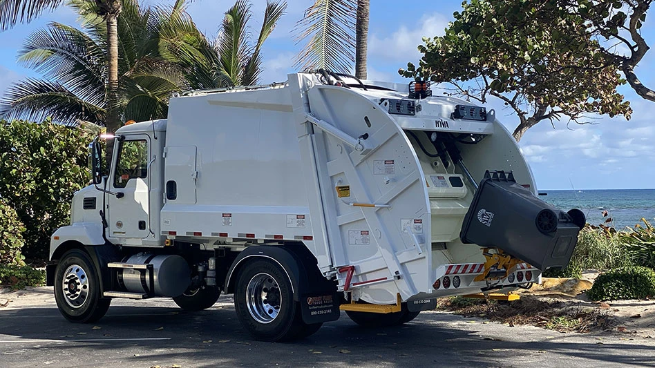 photo of a white rear-loader waste collection vehicle