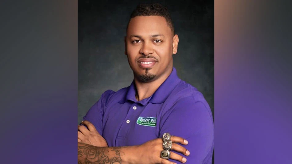 photo of a black man with arms crossed, smiling