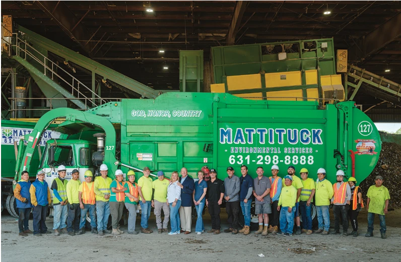 group of people in front of a green waste truck