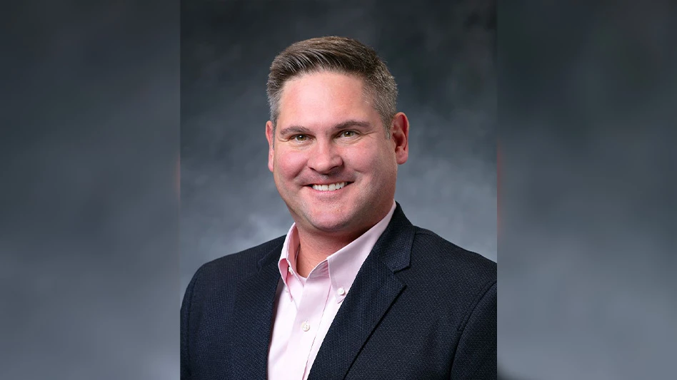 man smiling, wearing black suit coat and light pink dress shirt