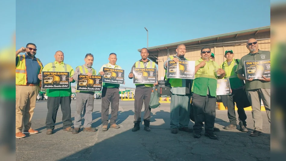 group of people in high-vis vests holding signs