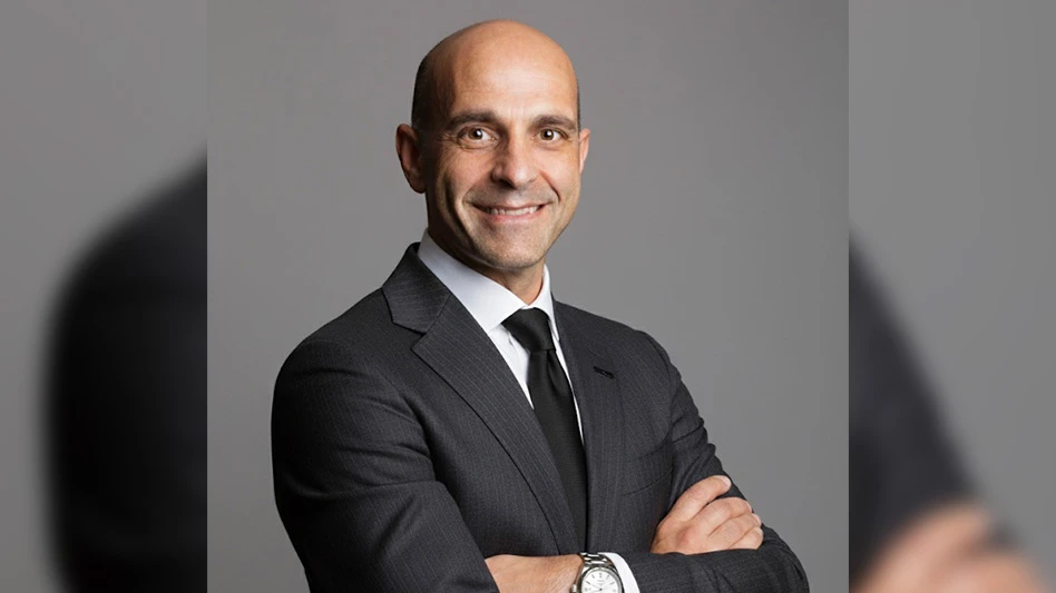 man in suit and tie with arms crossed smiling