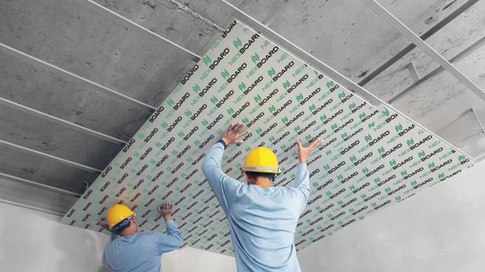 two people in yellow construction helmets install construction panel on ceiling