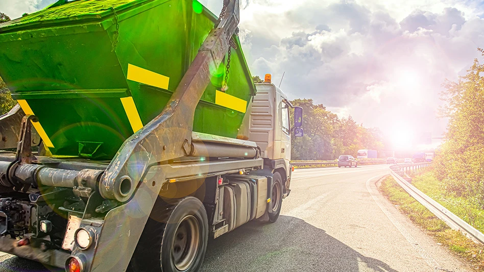Recycling truck driving into the sunset