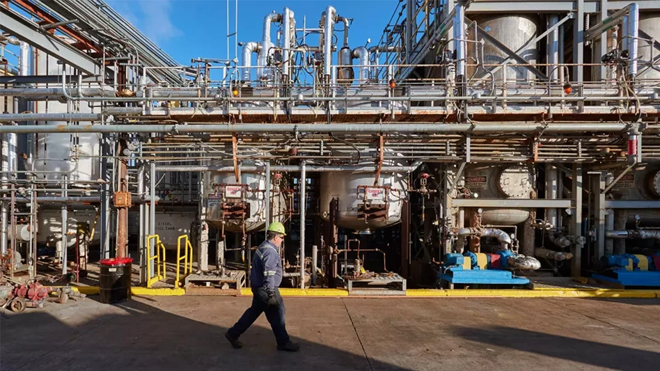 man walking in front of industrial waste management equipment