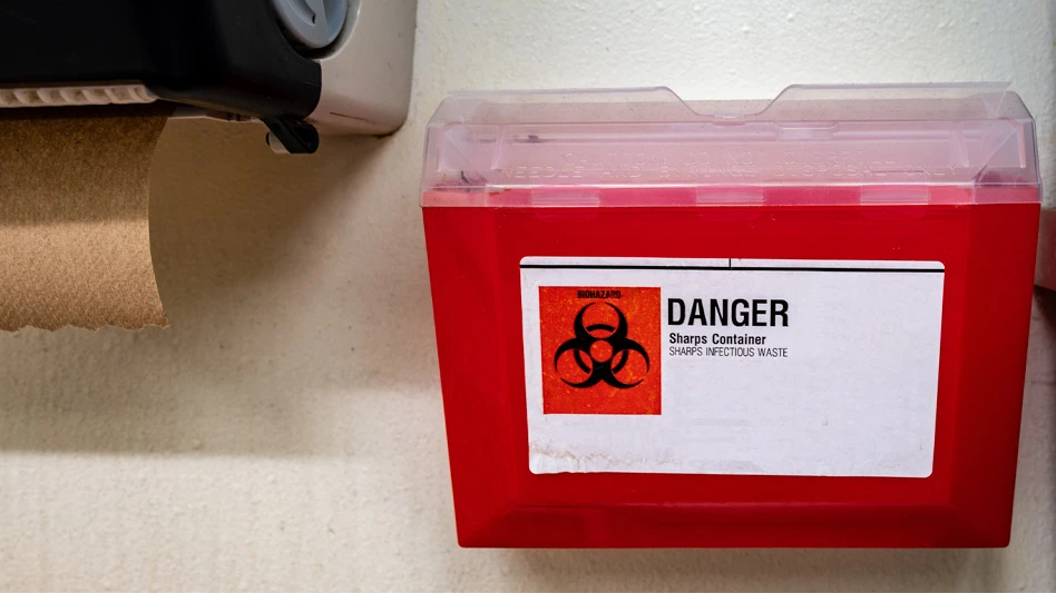 red medical waste/sharps container on wall
